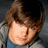 A pixelated image of a person with brown hair and a gray jacket, showing two sequential poses with slight head movement and pink text at the bottom.