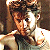 Pixelated image of a person with light brown hair and white clothing on the left, next to green text reading "Original Icons .com" on a dark green background.