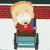 Pixelated cartoon character with blonde hair sits in a chair, wearing red shirt and blue jacket; background has horizontal stripes.