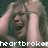 Pixelated image of a person with light skin covering their face with both hands, wearing a dark top, with white text reading 'heartbroken' at the bottom.