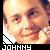 Pixelated close-up of a person's face with light skin tone, visible eyes and mouth, wearing dark clothing with white collar detail; text 'JOHNNY' in blocky font at bottom.