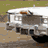 Animated sequence showing a white convertible car, license plate '1 HOGG', and a man in a white cowboy hat and shirt.