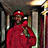 Pixelated figure in red attire holding a microphone, standing before columns and warm lighting.