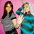 Two figures stand against a pink background; left figure has long brown hair and gray top, right figure wears teal clothing with arm raised.