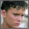 A pixelated animated sequence showing a person's face transforming into a simplified cartoon avatar with red shirt and blue background.