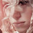 Pixelated close-up of a person's face with visible eyes, nose, and mouth on a light background.
