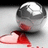 A metallic sphere rests on a red and white surface with a dark shadow beneath it.