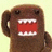 Brown plush character with wide red mouth and white teeth on light background, surrounded by bright green with pink pixelated text