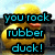 Pixelated image of a yellow rubber duck with orange beak against light blue sky background, overlaid with cyan text reading "you rock rubber duck!" in three lines.