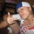 A person wearing a blue and white cap and red-and-white patterned clothing gives a thumbs-up gesture with a slight head tilt.