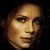 Pixelated close-up of a person's face with warm lighting and dark background, rendered in low-resolution 256x256 pixels.