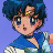 Pixelated character with blue hair and blue eyes, wearing a blue top with white and green accents, against a solid light blue background.