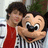 Two cartoon characters in striped shirts and red scarves, one with a red heart symbol above its head, against a blurred background.