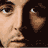 Pixelated close-up of a person's face with visible eye, nose, and mouth features against dark background.