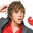 Pixelated image of a person with brown hair wearing a red and dark gray jacket against a white background.