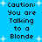 Blue background with white starbursts and repeated black pixelated text reading "Caution: You are Talking to a Blonde" in four vertical sections.