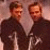 Two men in dark clothing stand side-by-side against a light background with green text reading AND SHEPARDS WE SHALL BE...