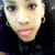Pixelated close-up of a person's face with light skin tone, dark eyes, and pink lips against a dark background.