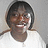 Pixelated static image of a person with short dark hair wearing a white top against a light gray background.