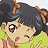 Pixelated character with dark hair and brown braids wears light green top with pink accents, large expressive eyes, and a slight smile against light background.