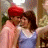 A person wearing a red turban and light blue sleeveless top, with brown hair, in two sequential poses showing slight head movement.