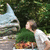 Animated sequence showing a child in a white shirt kissing a stone gargoyle statue against a green hedge background.