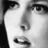 Black-and-white pixelated close-up of a human face with visible eyes, nose, and mouth features in grayscale tones.