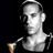 Pixelated grayscale image of a person holding a microphone against black background with visible dithering and anti-aliasing artifacts.