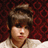 Pixelated image of a person with brown hair against a red patterned background, surrounded by green pixelated text on black.