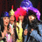 Two figures in yellow outfits with red hair and purple hats, one figure has a blue hat instead of purple.