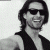 A pixelated grayscale portrait of a person with long hair and sunglasses on the left, next to green text reading 'Original Icons .com' on a dark green background.