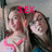Two women in a close pose with pink-trimmed tops, one woman's head slightly tilted, pink 'SEX' text overlaid on the image.