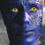 A pixelated static image shows a split-face character with dark blue and light blue skin tones, yellow eyes, and no visible clothing or background elements.