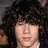 A person with voluminous curly dark hair and light skin appears in three distinct views showing subtle facial expression changes.
