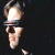 Pixelated icon of a figure in dark clothing holding a glowing white object against a black background.