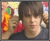 A sequence of animated frames showing a person in a dark shirt against a colorful floral background with red and green accents.